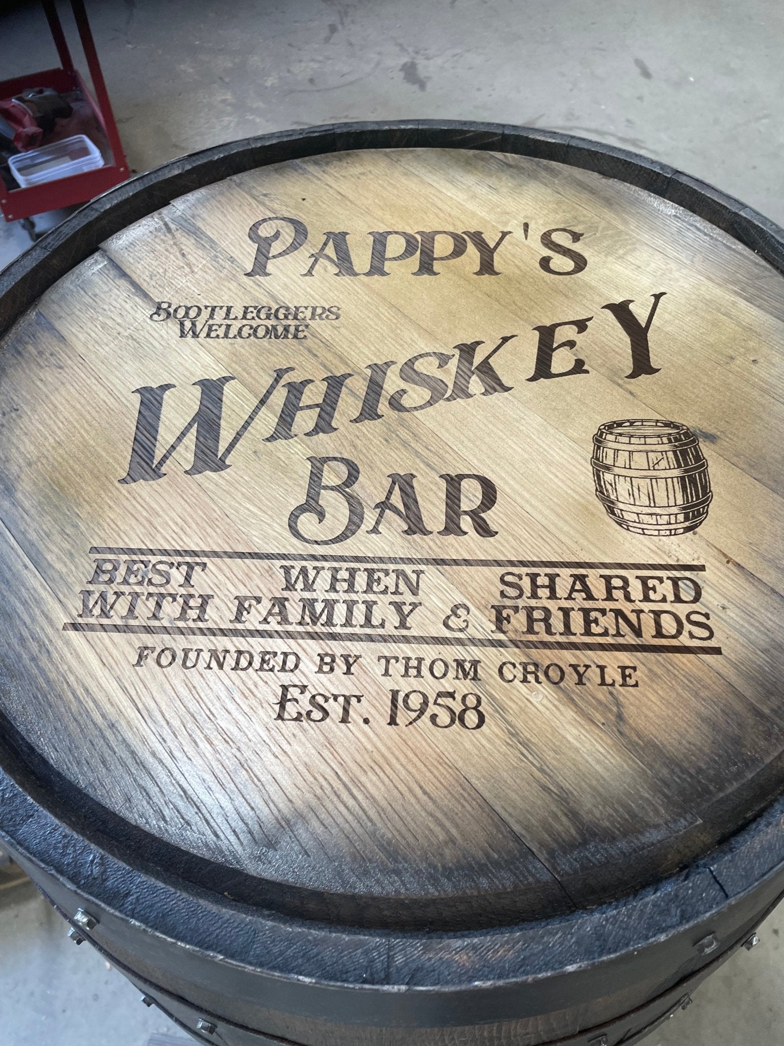 Artisan bourbon barrel bar sign customized with precision laser-engraved personal heraldry on solid 22-inch white oak heads.
