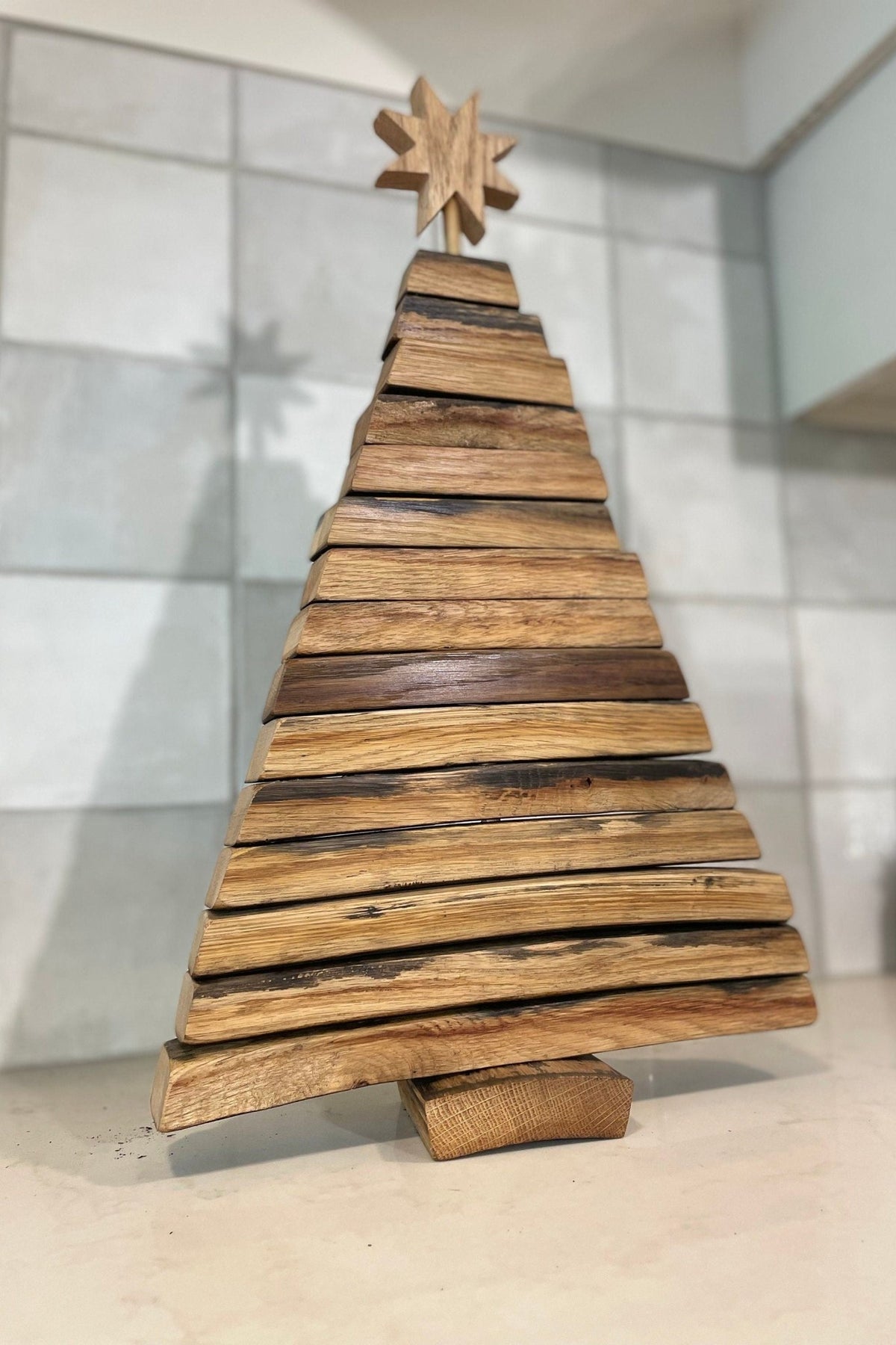 Bespoke barrel christmas tree highlighting the authentic curved stave geometry and rich charred grain of aged white oak.