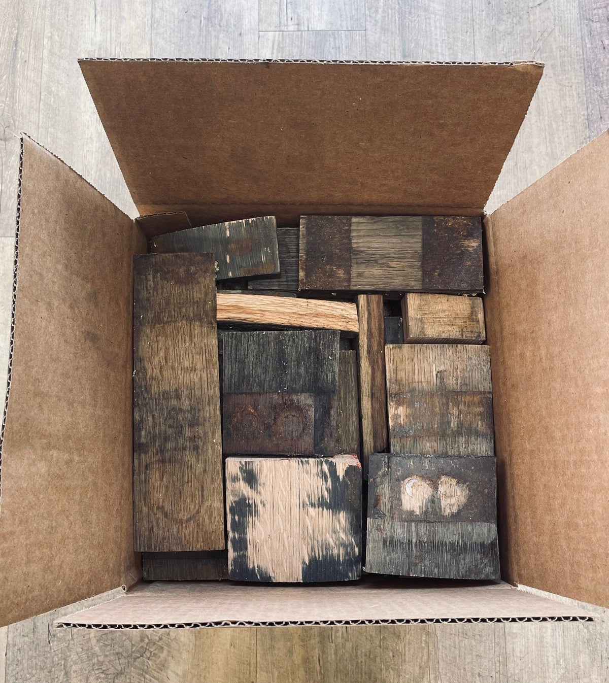 Bespoke whiskey barrel cutoffs packed to volume in a thirty-two pound reserve carton with varied stave lengths and widths.