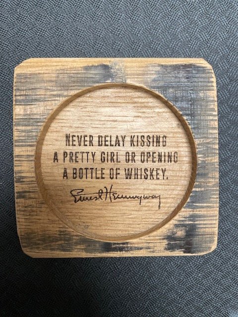 Bespoke whiskey quote coasters detailed with laser-engraved Hemingway typography inside a milled three-inch circular well.