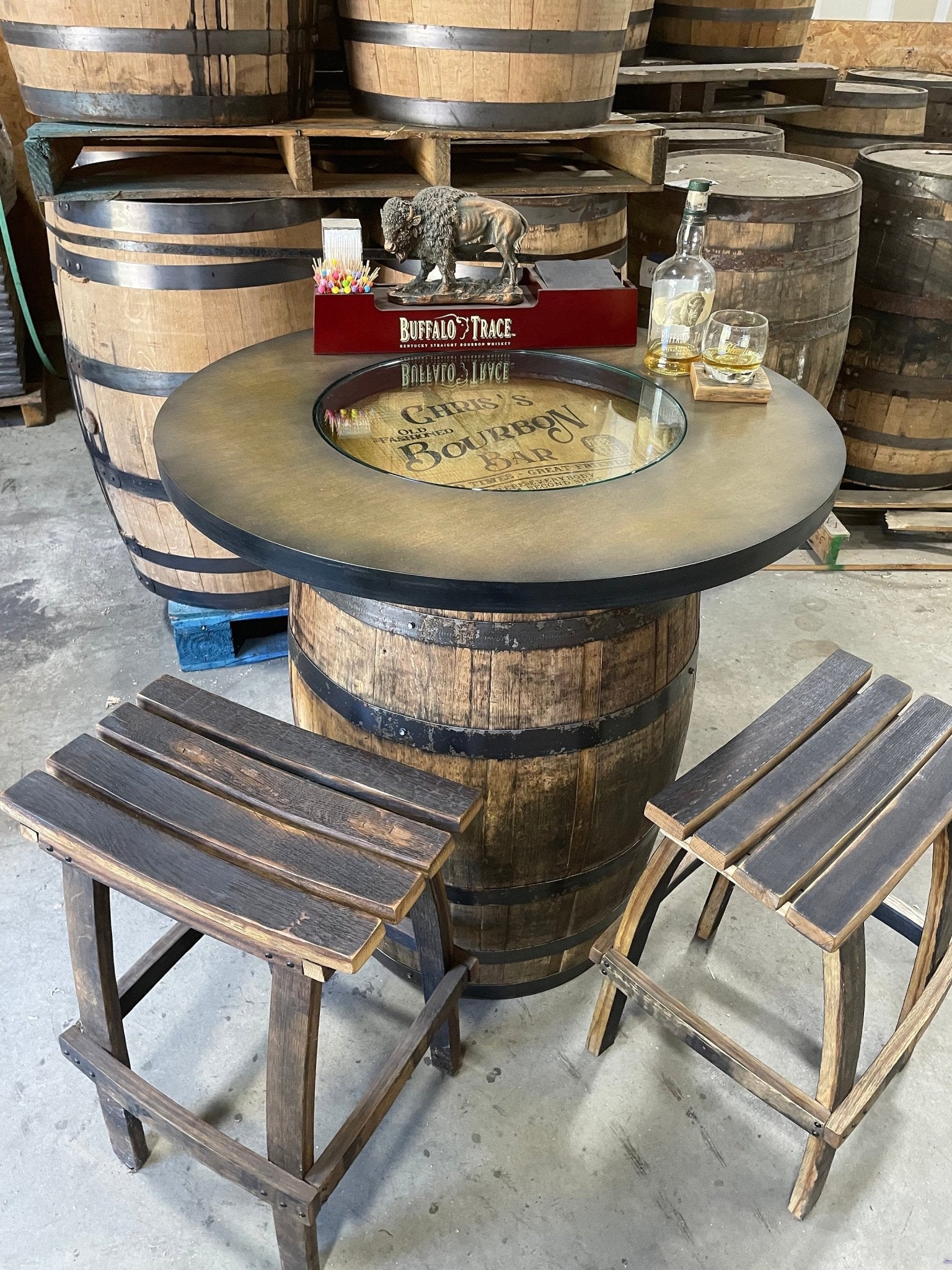 Bespoke bourbon barrel table crafted from reclaimed whiskey barrels featuring magnetic cabinet closure and glass tabletop