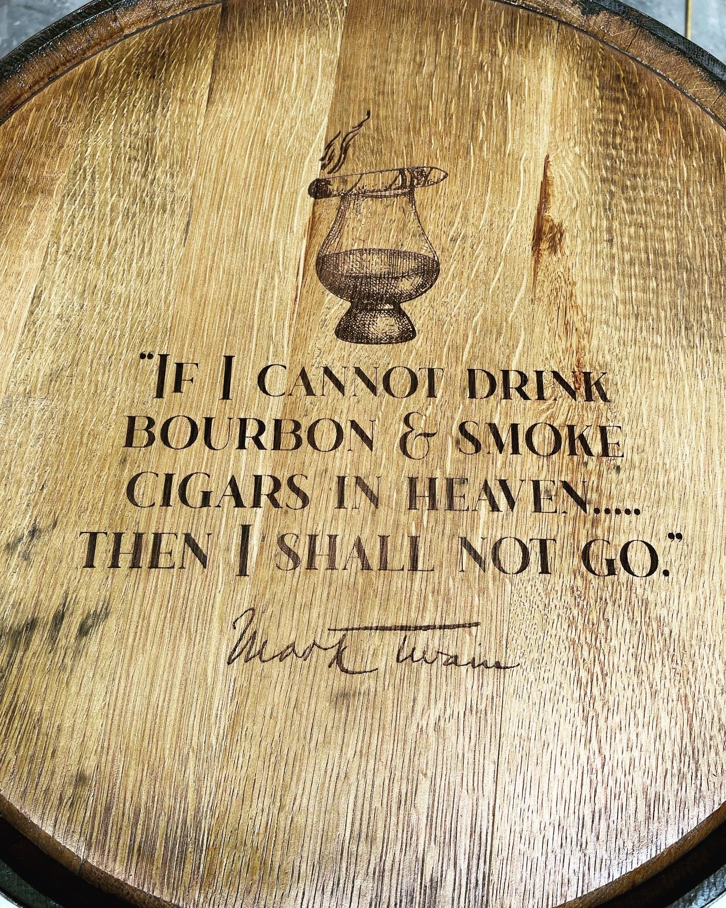 Custom barrel table decorated with custom laser-engraved quotes and custom script on sealed bourbon barrel lid timber
