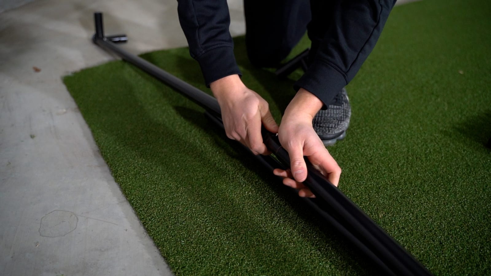 SimBox golf simulator hitting mat being installed – premium green turf for indoor golf setup