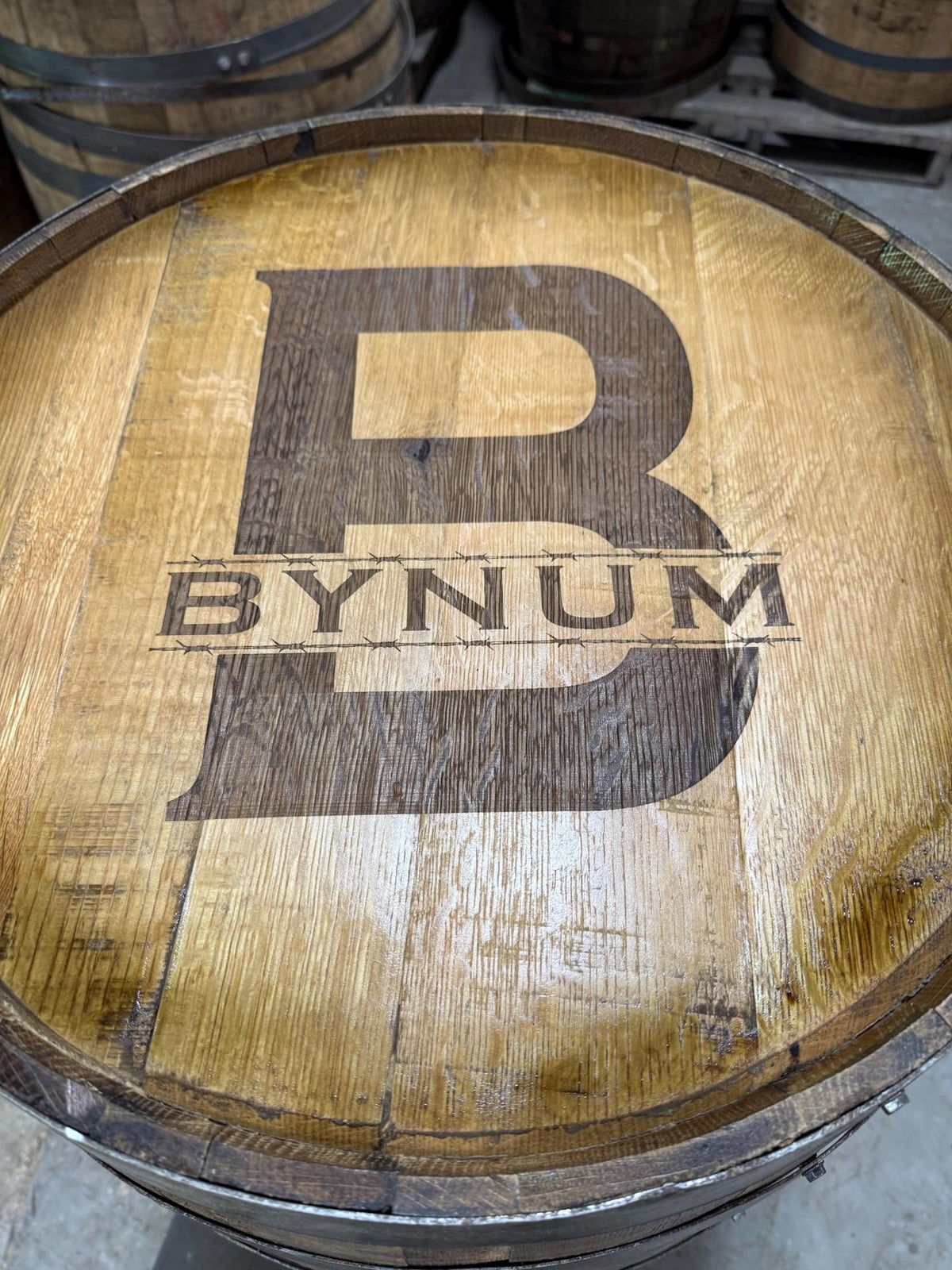 Bespoke whiskey billiards cue cabinet detailed with bold personalized family monogram laser etchings on reclaimed oak lids.