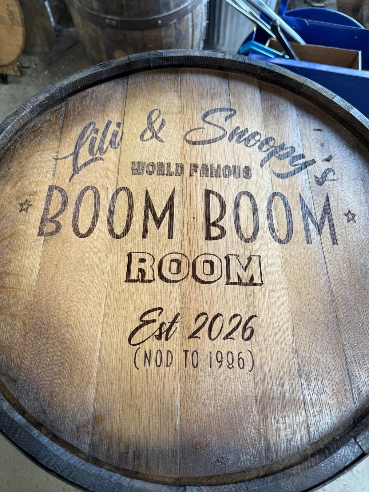 Artisan whiskey billiards cue cabinet tailored with bespoke lounge typography engraved across solid spirit barrel heads.