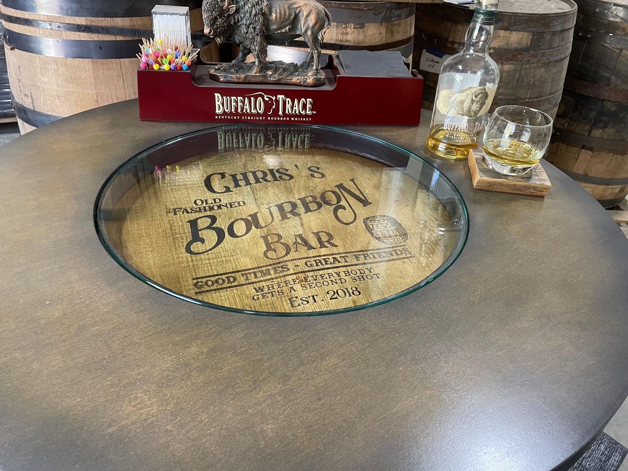 Artisan bourbon barrel table featuring an integrated glass shadow box interior display for spirit mementos and collectibles.