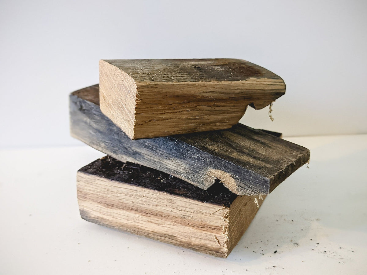 Custom bourbon barrel smoking wood revealing dense one-inch thick stave timber cross-sections and authentic charred edges.