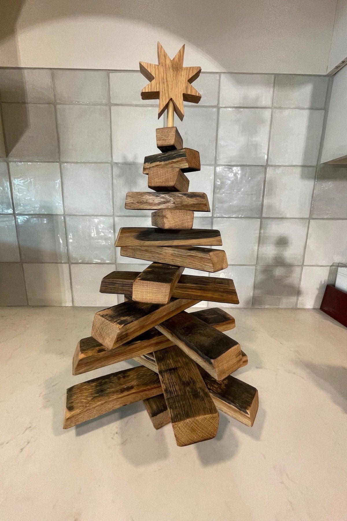 Artisan barrel christmas tree engineered with rotating American white oak staves and blackened distillery barrel accents.
