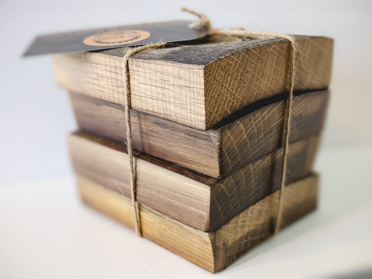 Bespoke whiskey quote coasters stacked in a four-piece collection tied with rustic jute twine for luxury gift presentation.