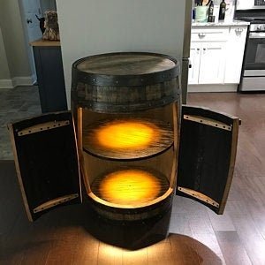 Artisan bourbon barrel cabinet featuring motion-sensing LED interior lighting across dual storage tiers at Home Man Cave.