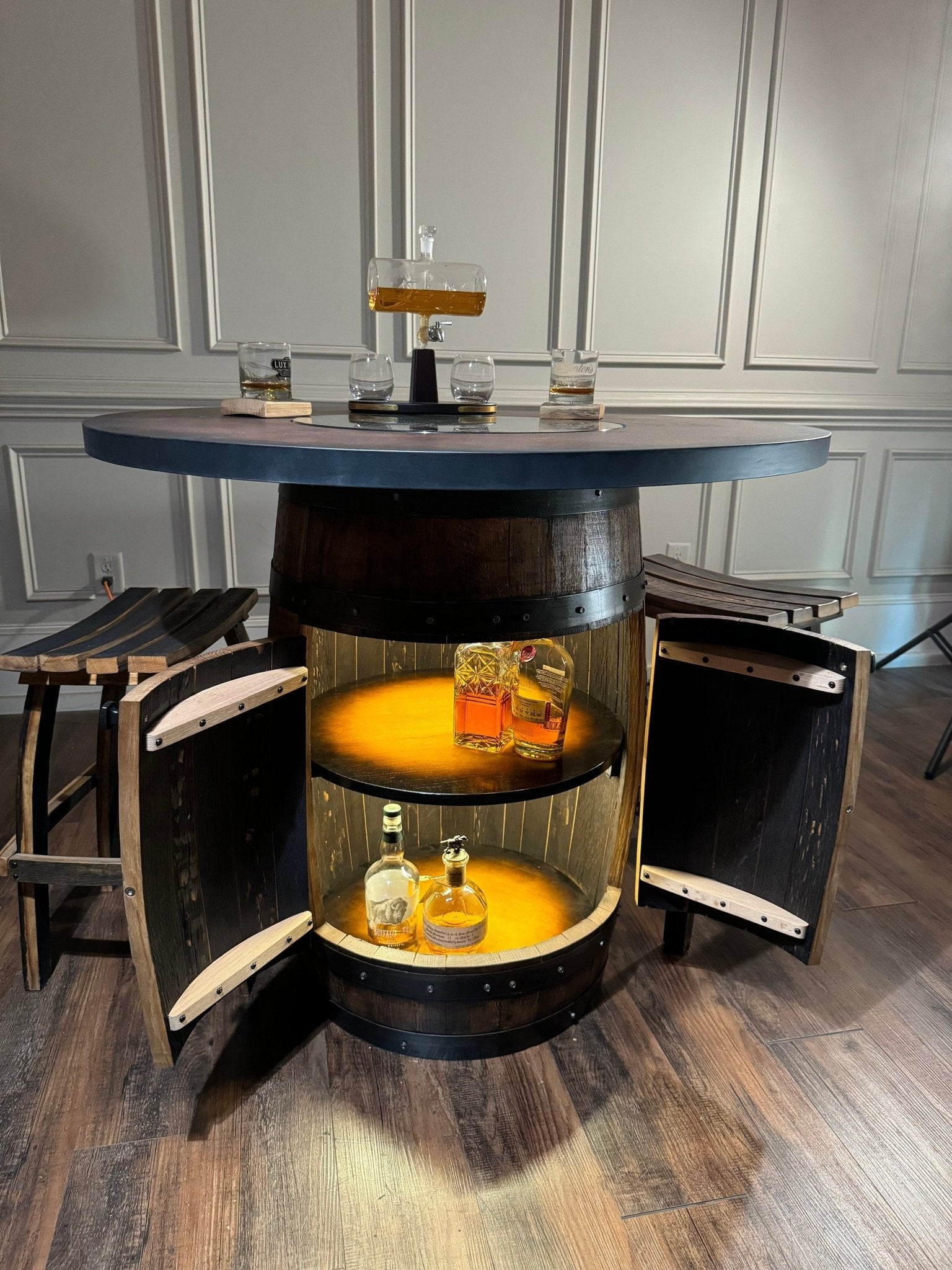 Bespoke bourbon barrel  table handcrafted with glass top insert and illuminated cabinet base inside home bar at Home Man Cave
