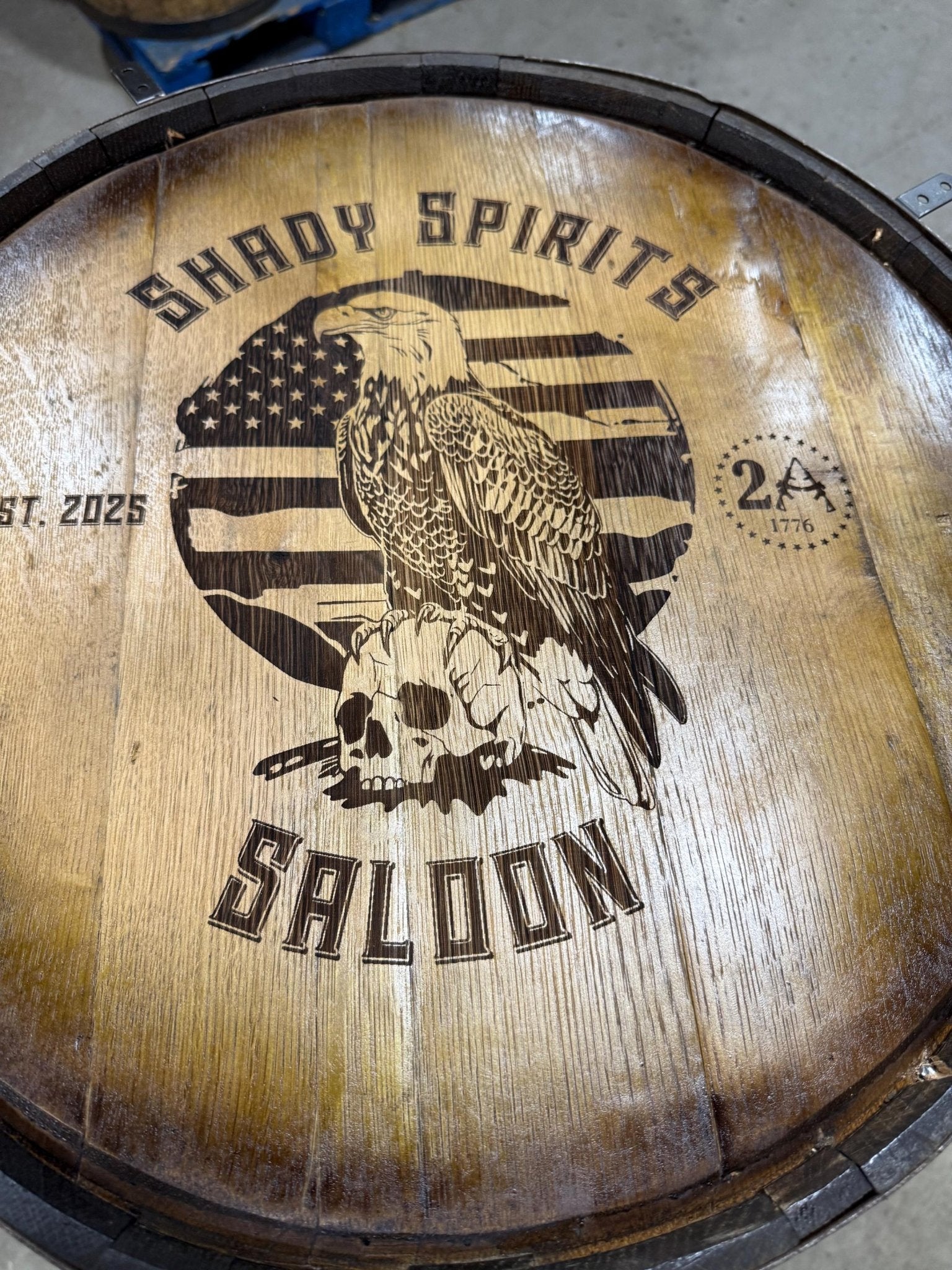 Custom barrel table displaying laser-carved eagle insignia graphics on rich aged natural whiskey barrel top timber