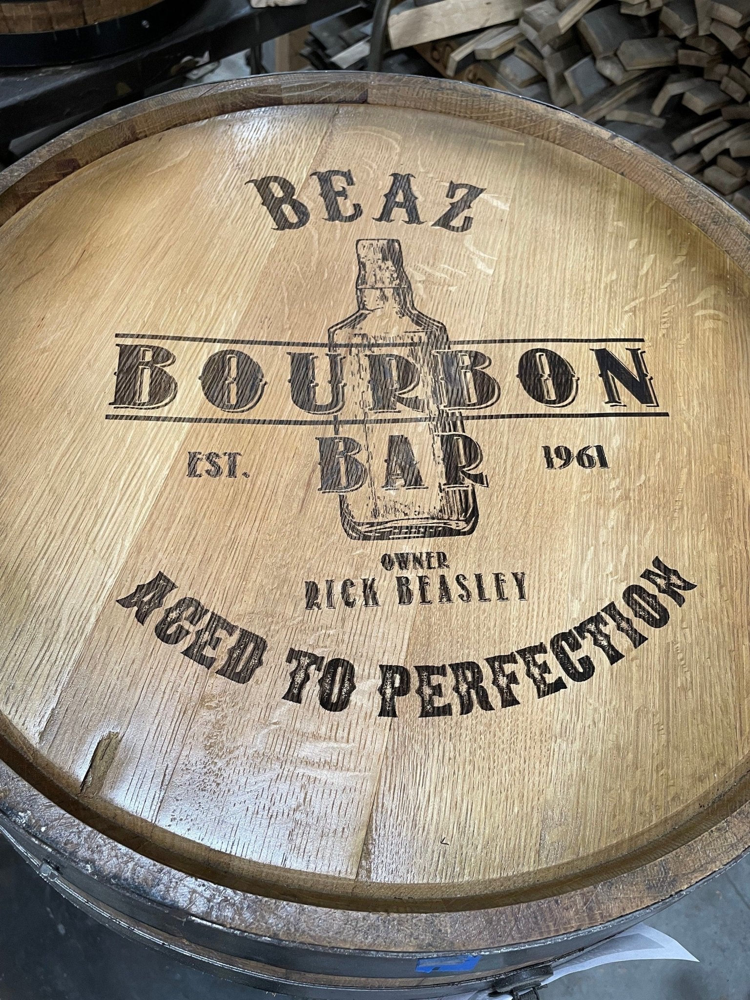 Custom barrel table displaying detailed laser-engraved established dates and distillery crests on natural oak timber