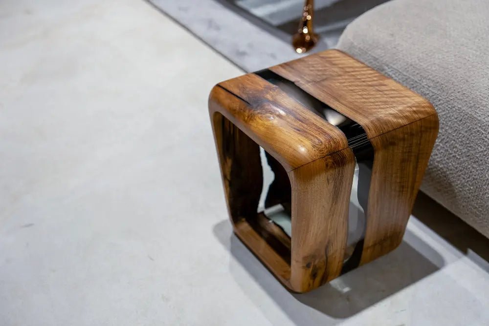 Precision-cast resin side table displaying dense natural hardwood figure permanently embedded within clear epoxy timber.