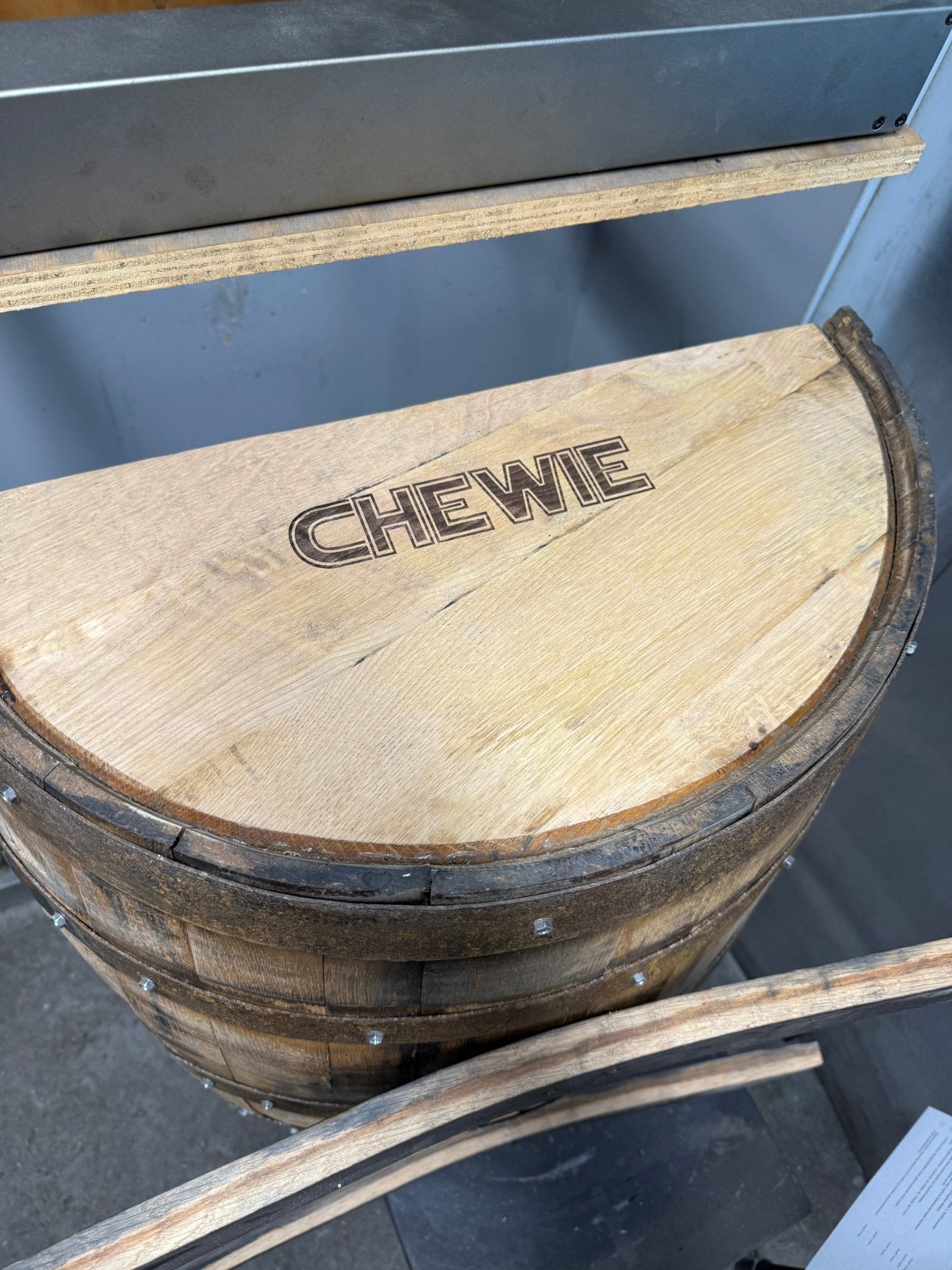 Artisan reclaimed dog bed displaying bespoke laser-etched name personalization's across solid reclaimed oak barrel timber.