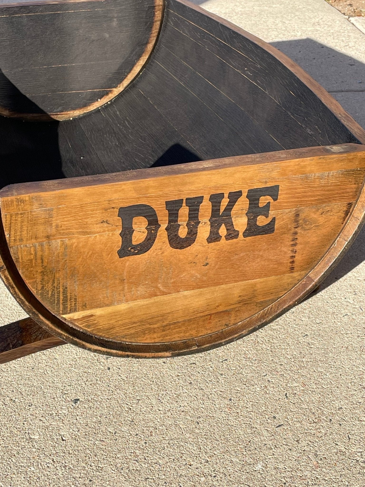 Custom reclaimed dog bed customized with precision laser-engraved pet monograms directly onto authentic cask barrel heads.