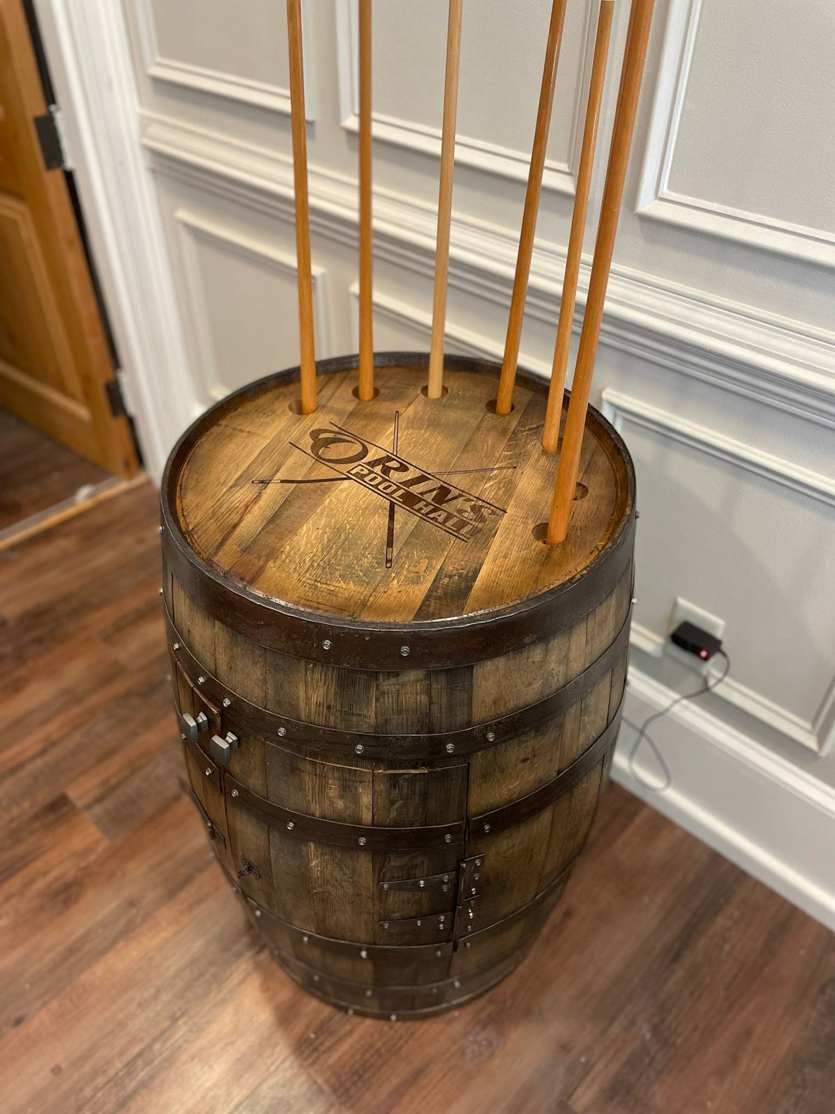 Custom whiskey billiards cue cabinet housing seven pool cues within an executive private estate game room at Home Man Cave.