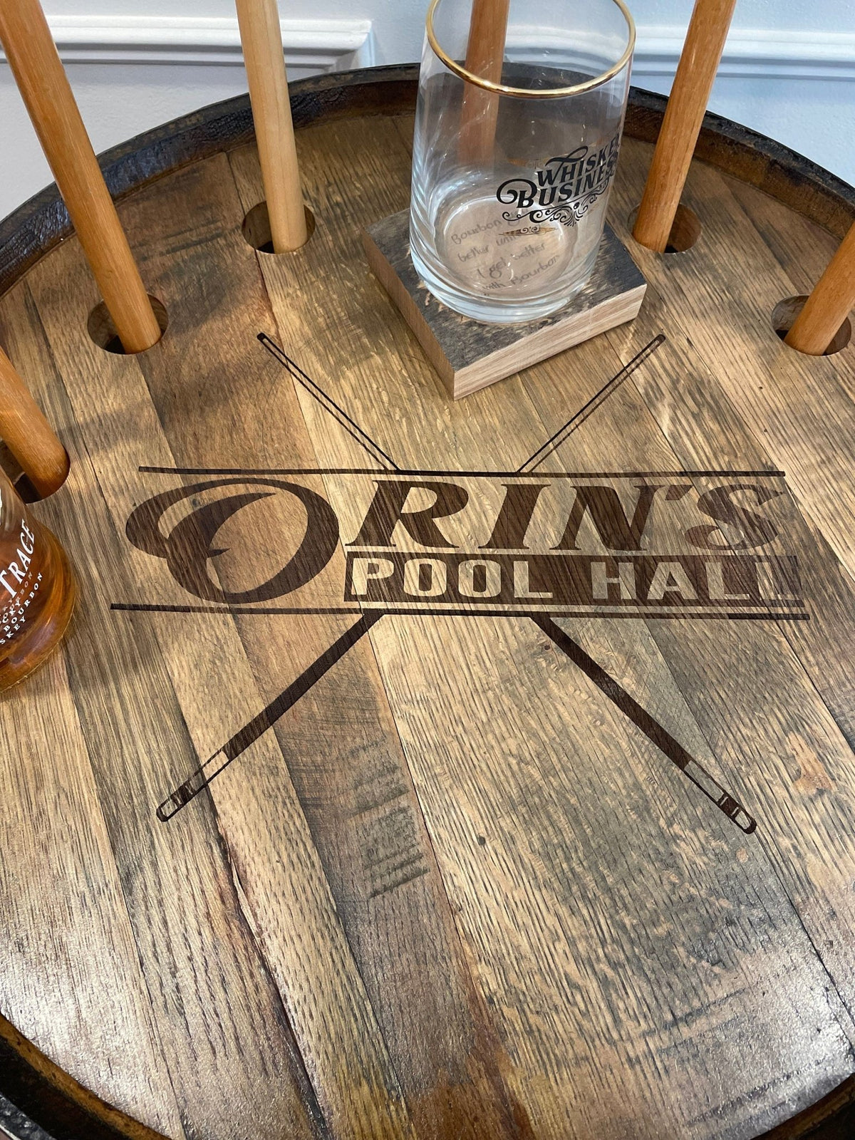Custom whiskey billiards cue cabinet featuring laser-engraved pool hall heraldry across authentic reclaimed barrel wood.
